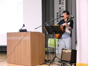 ギター片手に講演される石丸氏